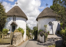 The thatched ‪Veryan Roundhouses, Veryan, Cornwall - mark the entrances to Veryan. There are five in total, originally built by the Trist Family they guard the village from evil as there are no corners in which the devil can hide! ‬